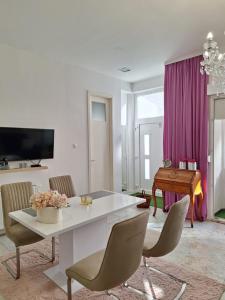 a living room with a white table and chairs at Apartman DJ in Đakovo