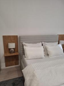 Un dormitorio con dos camas con sábanas y almohadas blancas. en Apartman DJ, en Ðakovo 30 fotos más