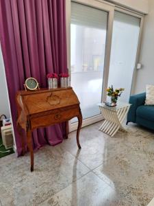 a living room with a table and purple curtains at Apartman DJ in Đakovo