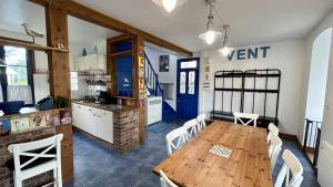 eine Küche und ein Esszimmer mit einem Holztisch und Stühlen in der Unterkunft Sans Souci, maison familiale pour 8 personnes in Cayeux-sur-Mer