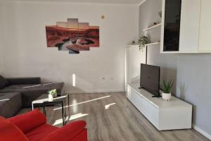 uma sala de estar com um sofá e uma televisão em Apartman Valentina em Podstrana