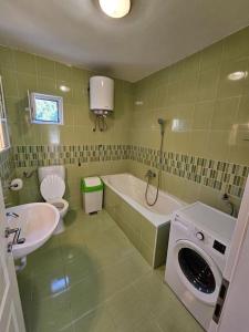 uma casa de banho com um lavatório e uma máquina de lavar roupa em Apartman Valentina em Podstrana