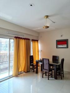 a dining room with a table and chairs and a window at Entire place-4BHK Apartment Bashundhara R/A in Dhaka