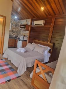 ein Schlafzimmer mit einem Bett in einem Zimmer in der Unterkunft Chalé Pavão Recanto Buscapé SFX in São Francisco Xavier