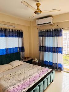a bedroom with a bed with curtains and a fan at Entire place-4BHK Apartment Bashundhara R/A in Dhaka