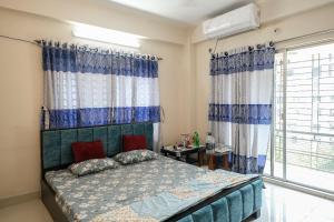 a bedroom with a bed with blue and white curtains at Entire place-4BHK Apartment Bashundhara R/A in Dhaka
