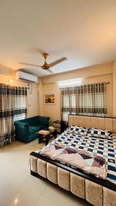 a bedroom with a large bed and a green couch at Entire place-4BHK Apartment Bashundhara R/A in Dhaka