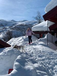 a woman walking a dog in the snow at Roni Chalet Hemsedal - Holdeskaret in Hemsedal