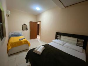 a bedroom with two beds with yellow and blue sheets at Casa Família com ar Vaga Praia do Centro Paraty in Paraty