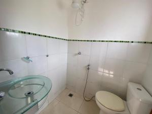 a bathroom with a toilet and a glass sink at Casa Família com ar Vaga Praia do Centro Paraty in Paraty +9 photos