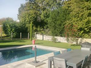 una piscina con mesa y sillas junto a ella en Suite de 38m2 spécial JO, en Veneux-les-Sablons