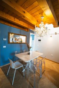 - une salle à manger avec une table et des chaises dans l'établissement Le Finestre Apartments Muggia, à Muggia