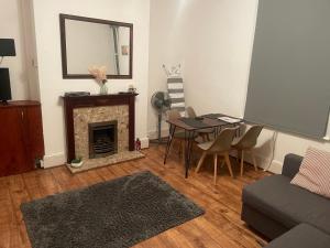 a living room with a table and a fireplace at Modern One Bed Apartment Greenwich in London