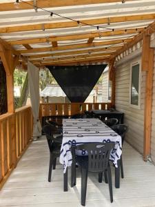 a black and white table and chairs on a patio at Mobil home Aventura 6-8 personnes tout confort in Saint-Brevin-les-Pins
