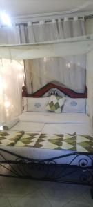 a bed with a canopy with two pillows on it at WAYPOINT SUITES HOTEL in Kabale