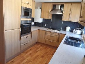 a kitchen with wooden cabinets and a counter top at Dunabban Road, Inverness city in South Kessock