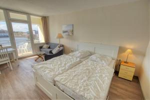 - une chambre avec un lit, une chaise et une fenêtre dans l'établissement Strandhotel, App 1SH308, à Heiligenhafen