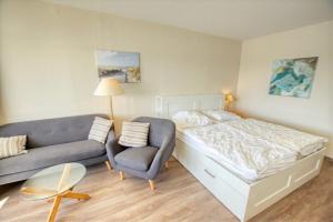 - une chambre avec un lit et un canapé dans l'établissement Strandhotel, App 1SH308, à Heiligenhafen