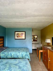 a bedroom with two beds and a blue wall at Budget Inn in Punta Gorda
