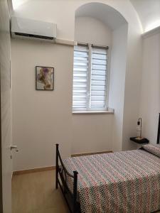 1 dormitorio con cama y ventana en L'amurusa, en Noto