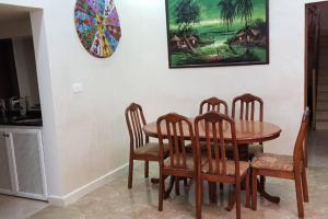 a dining room with a wooden table and four chairs at Breeze House in Kafr Khall