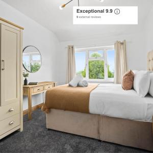 Schlafzimmer mit einem Bett, einem Schreibtisch und einem Fenster in der Unterkunft Luxurious 3 Bedroom House with Parking 73B - Top Rated - Netflix - Wifi - Smart TV in Holly Lane