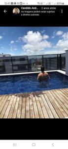 um homem numa piscina no topo de um edifício em Ap em Maceió todo equipado á 150m da praia de Ponta Verde em Maceió