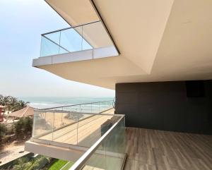 um quarto com uma varanda com vista para o oceano em Kololi Sands Apartments em Sere Kunda