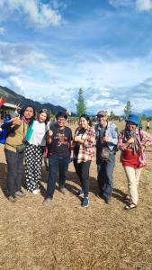 een groep vrouwen in een veld bij Pintu Biru Hostel in Wamena