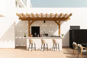 a kitchen with a bar with stools at Amarilla Golf Residences in San Miguel de Abona