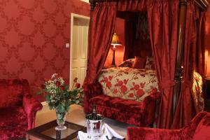 a bedroom with a bed with a chair and a table at Mansion House Hotel in Elgin
