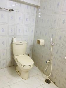 La salle de bains est pourvue de toilettes et d'un rouleau de papier toilette. dans l'établissement Penthouse -Private Room with Attach bath Ac & Rooftop, à Dhaka
