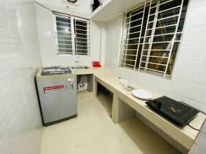 La salle de bains est pourvue d'un comptoir et d'un petit réfrigérateur. dans l'établissement Penthouse -Private Room with Attach bath Ac & Rooftop, à Dhaka