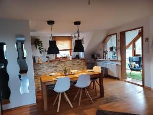 uma cozinha e sala de jantar com uma mesa de madeira e cadeiras em Ferienwohnung am Sendberg em Frielendorf