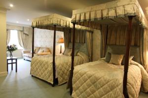 1 dormitorio con 2 camas y sofá en Mansion House Hotel en Elgin
