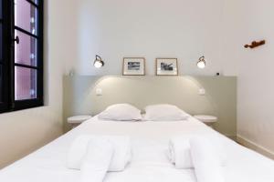 1 dormitorio con 1 cama blanca grande y 2 aseos en Superbe maison au coeur de la ville à deux pas de la Côte des Basques, en Biarritz