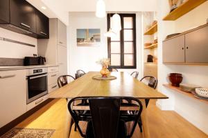 cocina y comedor con mesa de madera y sillas en Superbe maison au coeur de la ville à deux pas de la Côte des Basques en Biarritz