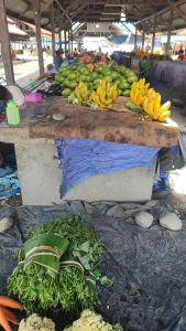 a table with bananas and other fruits and vegetables on it at Pintu Biru Hostel in Wamena