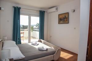 a bedroom with a bed and a large window at Guest House Tanja in Orebić