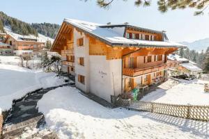 ヴィラール・シュル・オロンにあるChalet con Vistaの雪中の大木造家屋
