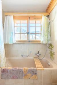 a bath tub in a bathroom with a window at Chalet con Vista in Villars-sur-Ollon