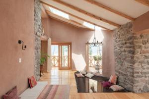 a living room with a stone wall and a couch at Cabaña Maras Peru in Maras