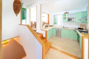 una cocina con armarios verdes y una escalera en Villa Carolina - jardín independiente, recién reformada. en Maspalomas