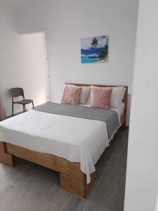 a bedroom with a large bed with a white bedspread at Cozy Lodge in Grand Gaube