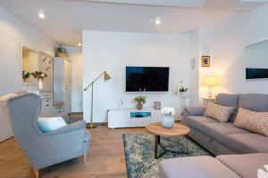 a living room with a couch and a tv at Apartment APARTMAN MIA in Brodarica