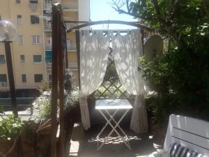 una pérgola con una mesa y una silla en un patio en APPARTAMENTO INCANTEVOLE CON GIARDINO, en Génova