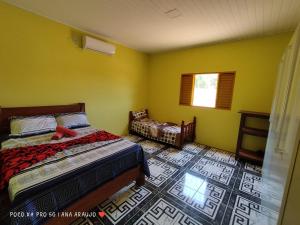 ボドケーナにあるCasa Confortável em Bodoquena.のベッドルーム1室(ベッド1台、椅子、窓付)