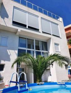 a house with a swimming pool in front of a house at Apartmani Avanti Becici in Becici