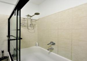 a bathroom with a bath tub with a shower at Designer Three Bd Apartment In NYC in New York