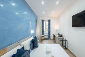 a bedroom with a white bed and a blue wall at Catone Luxury Rooms in Rome